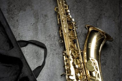 brass saxophone on gray table near black bag