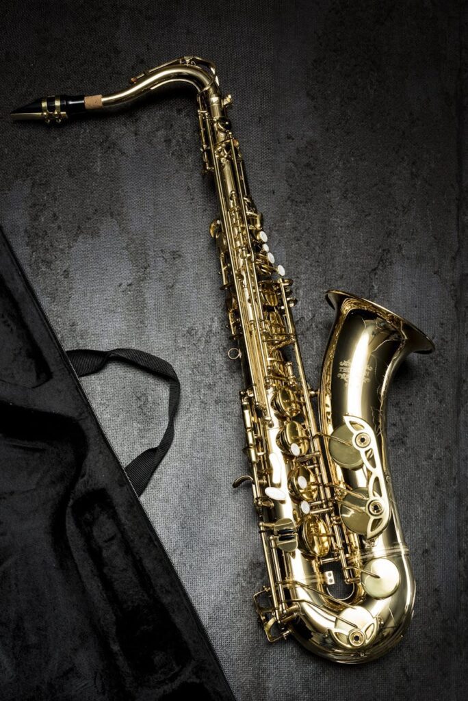 brass saxophone on gray table near black bag